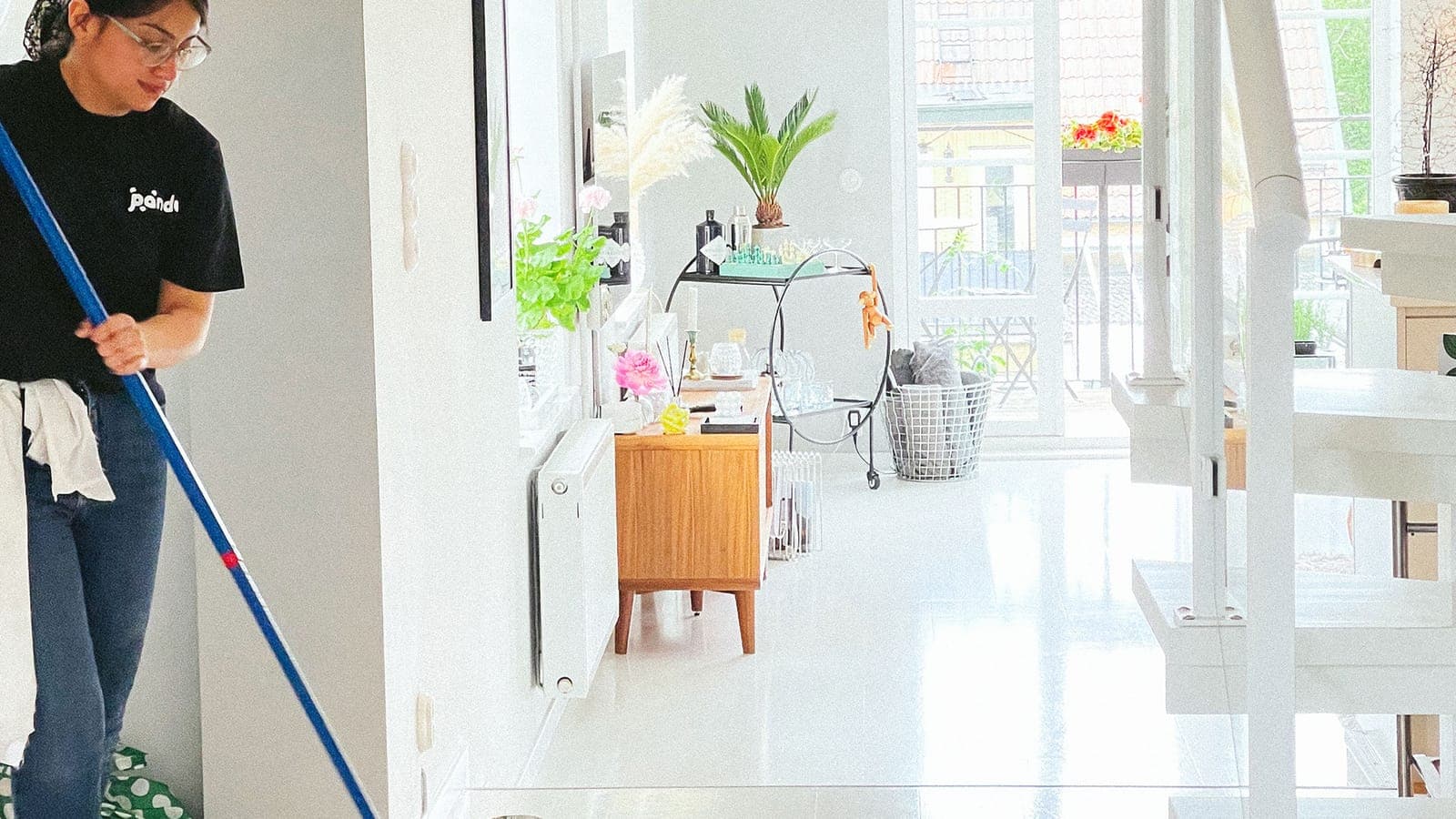 A cleaner mopping the floor in a white, bright room