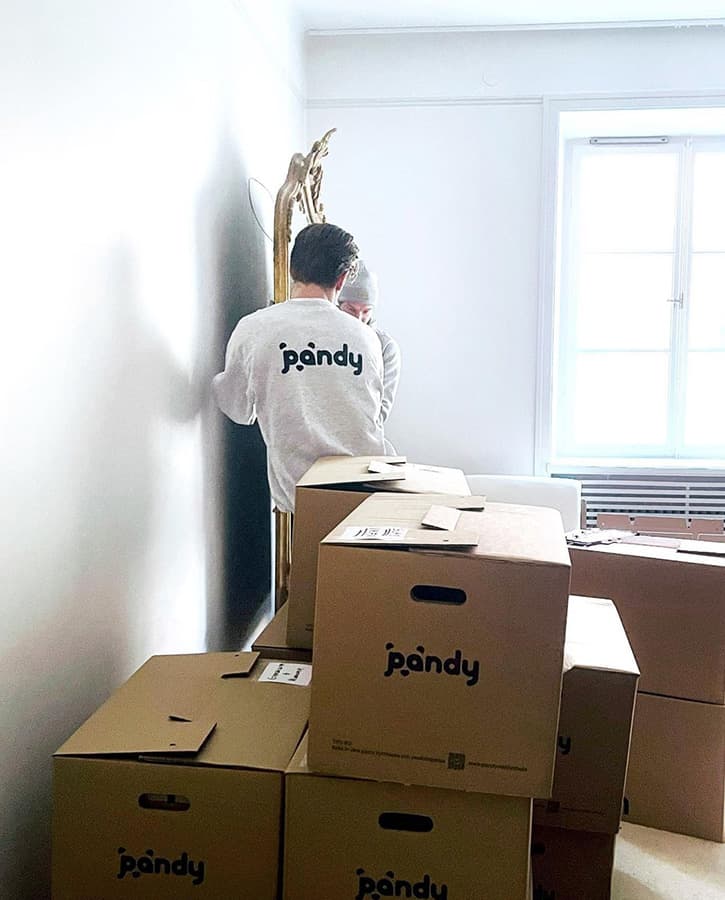 Pandy's movers lifting a large, heavy mirror off the wall