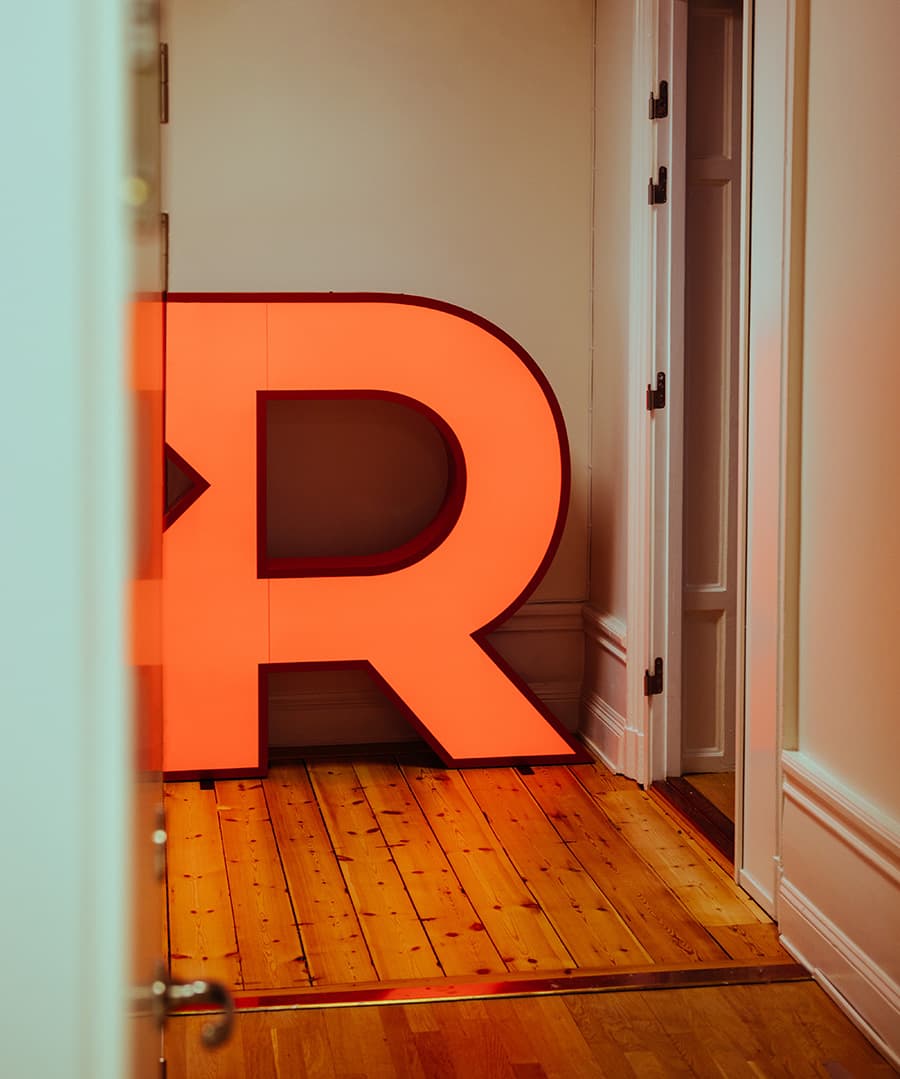 Redgert Comms logo as a floor lamp