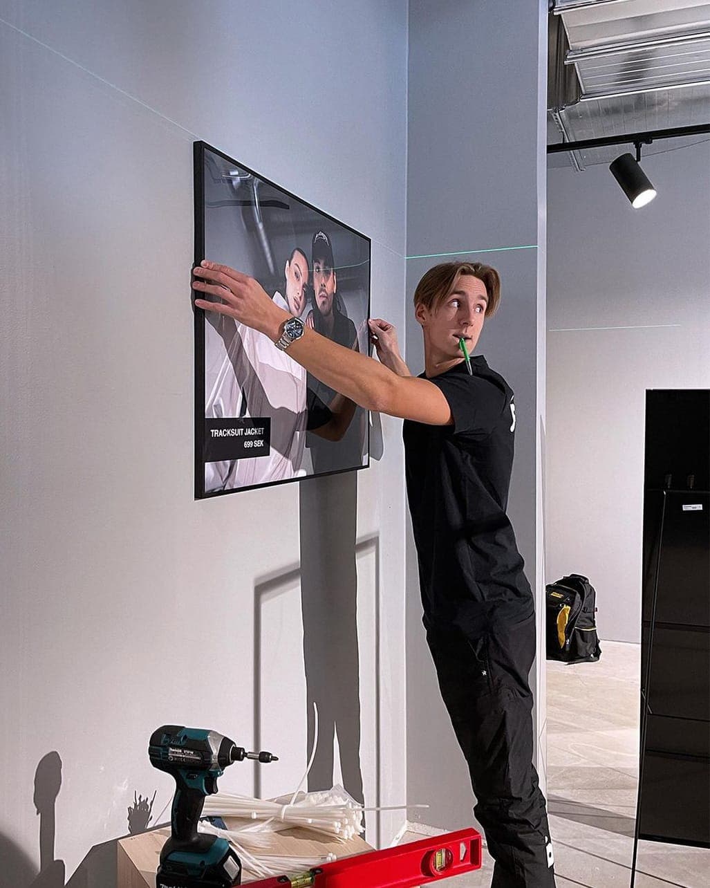 Pandy handyman hanging a picture on the wall using a laser