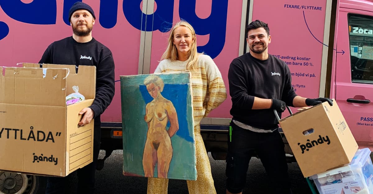The Pandy team with moving boxes and a painting in front of a pink wall